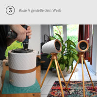 Schritt 3: der Subwoofer-Deckel wird verschraubt, daneben die fertig aufgebauten Satelliten auf Stativen im Wohnzimmer